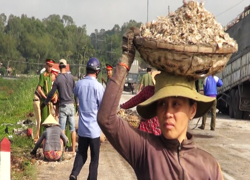 Người dân Quảng Ngãi giúp cảnh sát giao thông dọn dẹp củ mì đổ văng xuống đường tránh quốc lộ. Ảnh: Thạch Thảo.