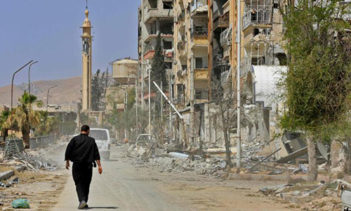 Một người đàn ông đi giữa những tòa nhà đổ nát ở Đông Ghouta, thành phố Douma, ngoại ô thủ đô Damascus ngày 20/4. Ảnh: AFP.