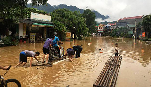 Người dân huyện Bá Thước dùng bè mảng di chuyển trên quốc lộ 217. Ảnh: Lam Sơn.