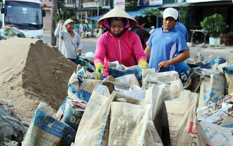 Người dân TP Nha Trang tất bật xúc cát chằng chống nhà. Ảnh: Xuân Ngọc.