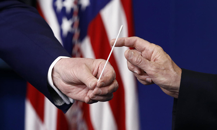 Tổng thống Mỹ Trump (trái) và Phó tổng thống Mike Pence cầm một mẫu gạc có thể dùng trong xét nghiệm nCoV tại họp báo ở Nhà Trắng hôm 19/4. Ảnh: AP.