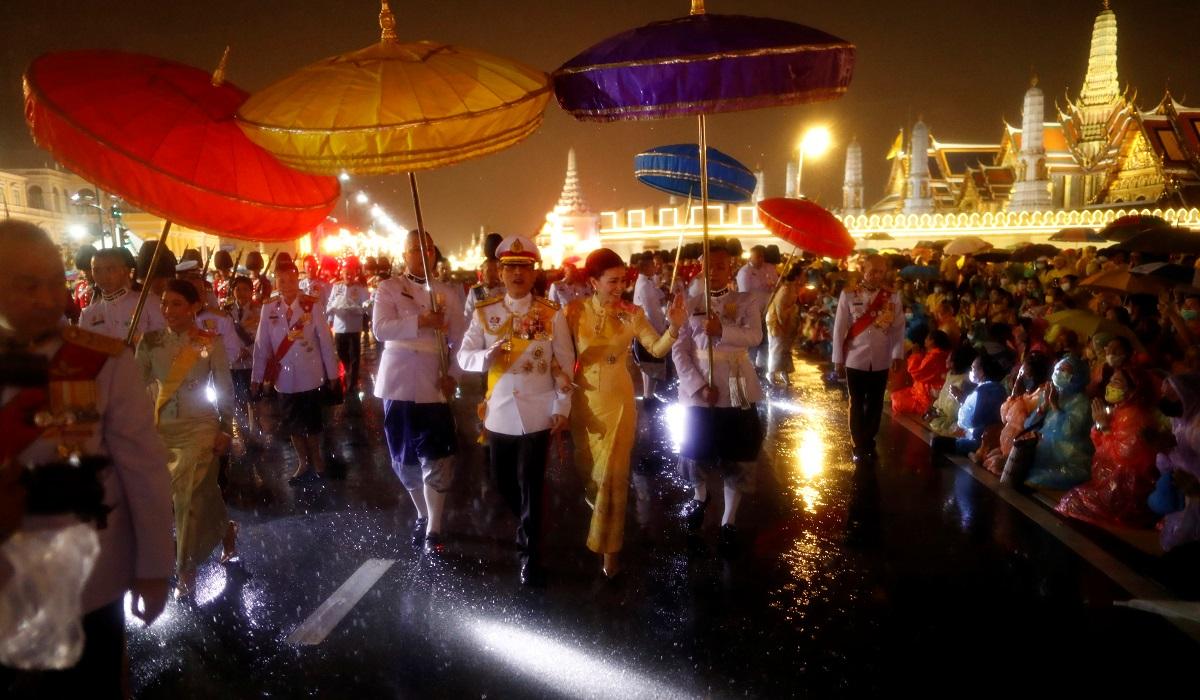 Nhà vua Maha Vajiralongkorn và Hoàng hậu Suthida chào người ủng hộ dưới mưa ở bên ngoài hoàng cung tối 13/10. Ảnh: Reuters.