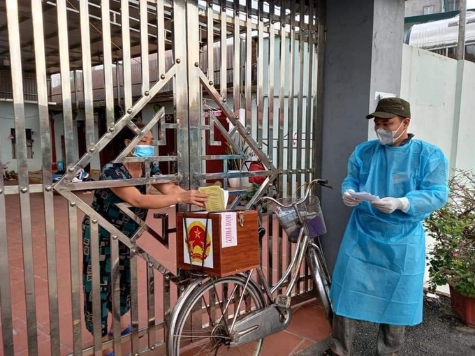 Lực lượng chức năng thôn Chùa, xã Tăng Tiến, huyện Việt Yên, tỉnh Bắc Giang dùng xe đạp chở hòm phiếu đến từng nhà để cử tri bỏ phiếu. Ảnh: Hữu Trình