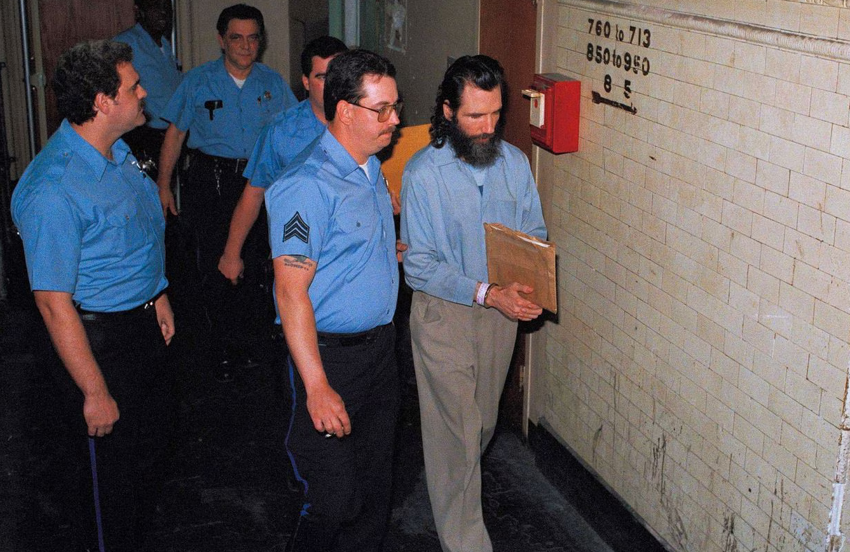 Gary Heidnik (râu dài) bị áp giải khỏi phòng giam ở Philadelphia sau khi bồi thẩm đoàn kết tội ngày 2/7/1988. Ảnh: AP